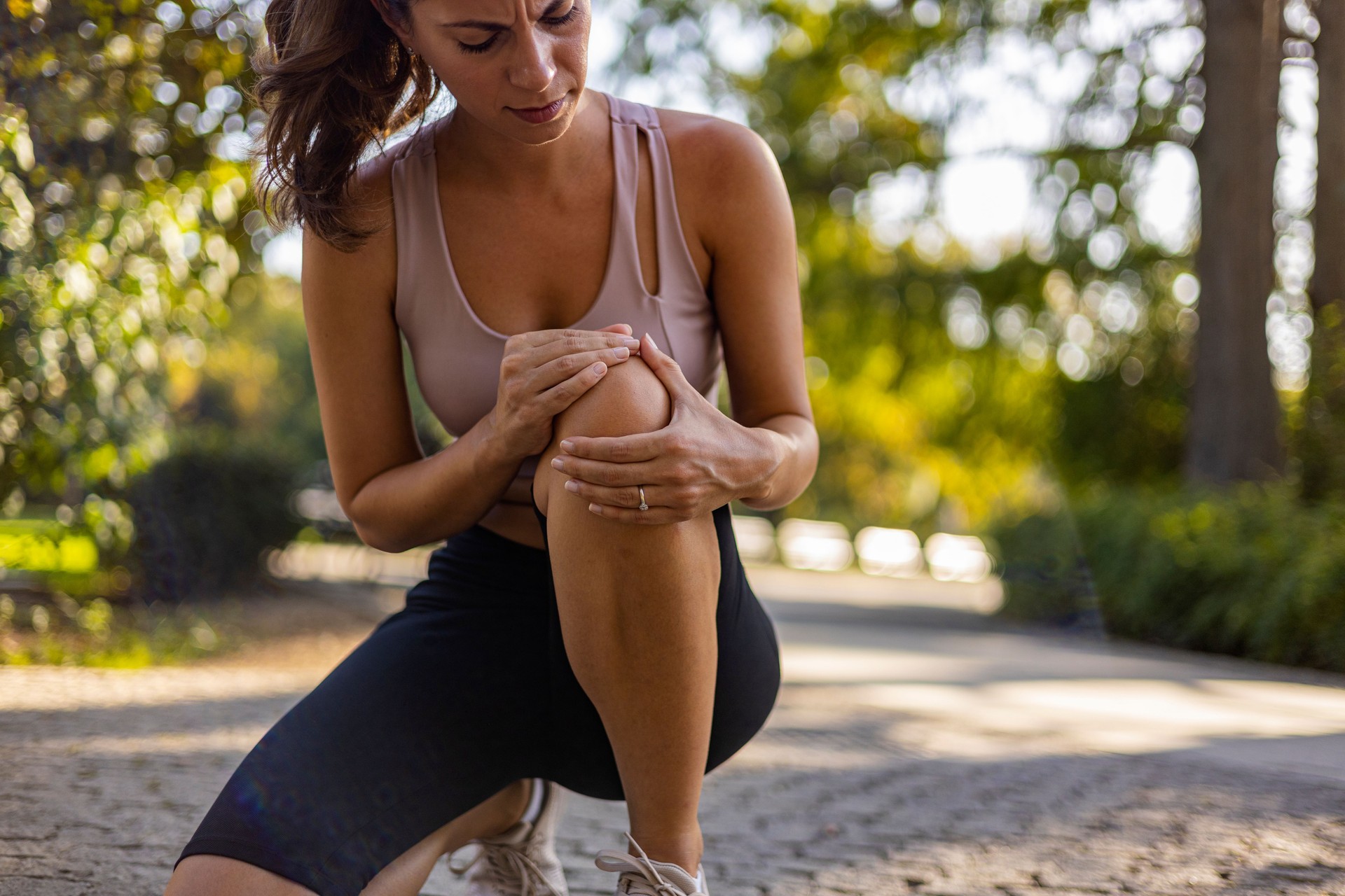 Young woman feeling pain in her knee. Young woman feeling pain in her knee.